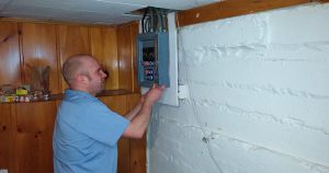 Electrician removing the cover from a fuse panel